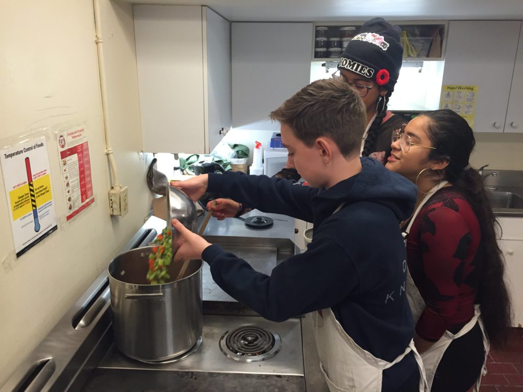 Photo of culinary arts project participants cooking in the commercial kitchen